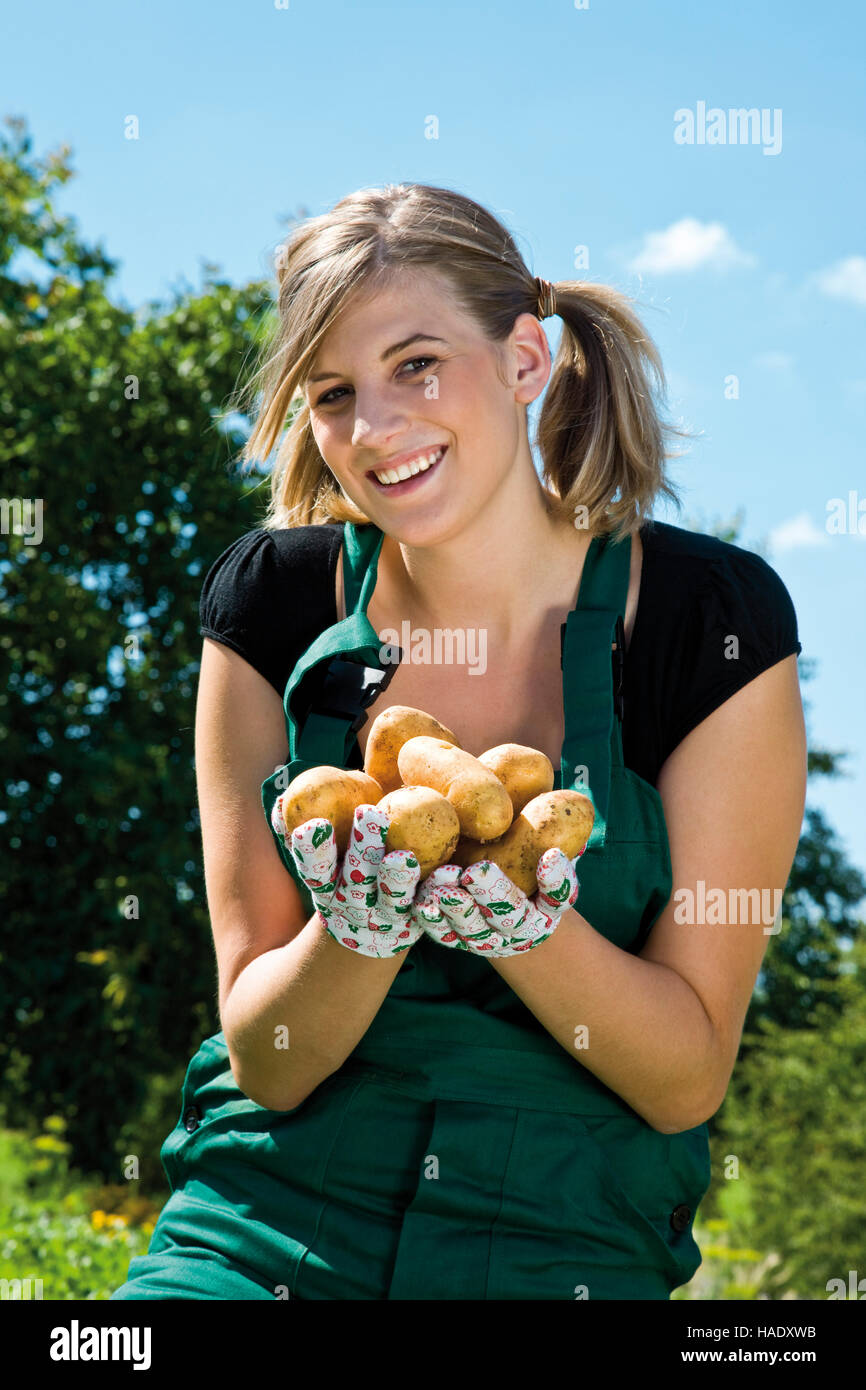 Young woman harvesting potatoes Stock Photo