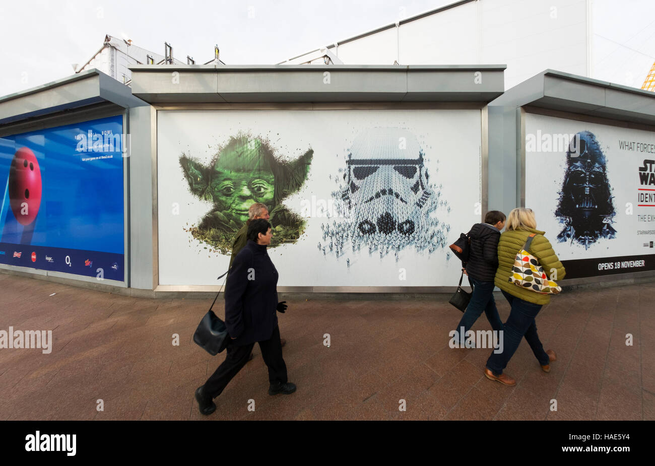 Visitors walk past Star Wars Identities exhibition posters at the O2 in North Greenwich, London UK Stock Photo