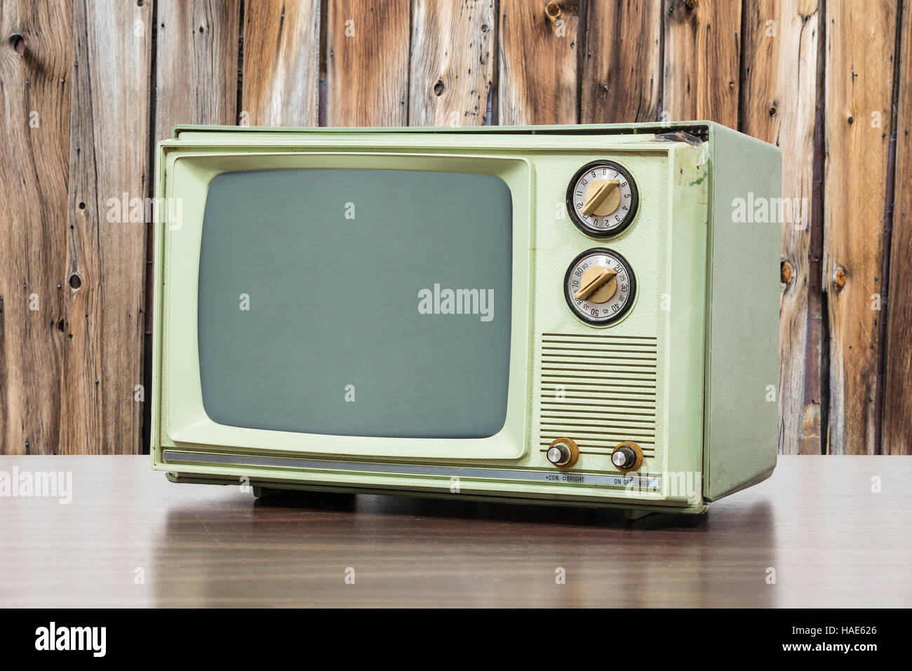Green vintage television with old wood wall. Stock Photo