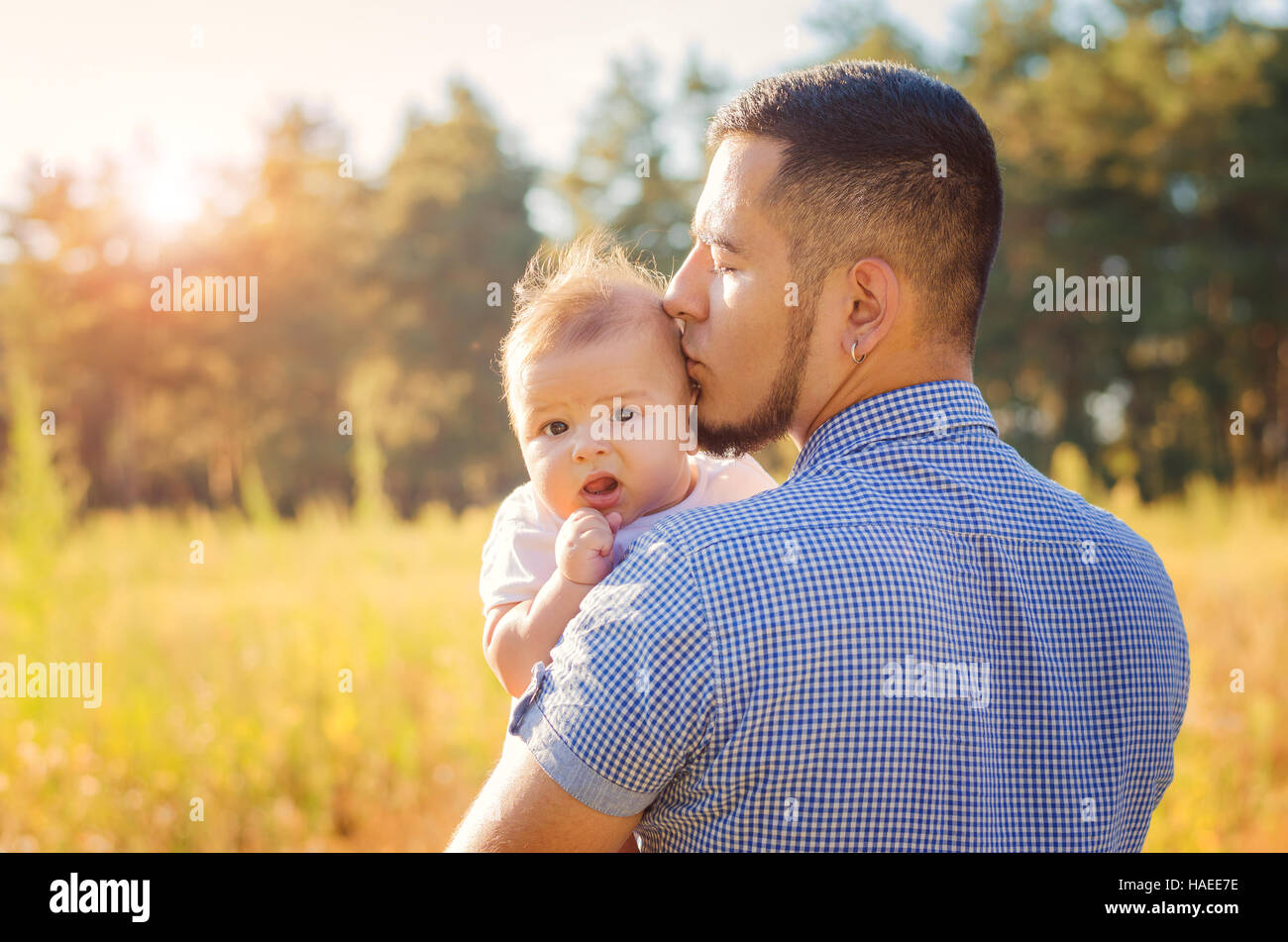 Young daddy kissing a baby. Walk autumn evening outdoors. Stock Photo