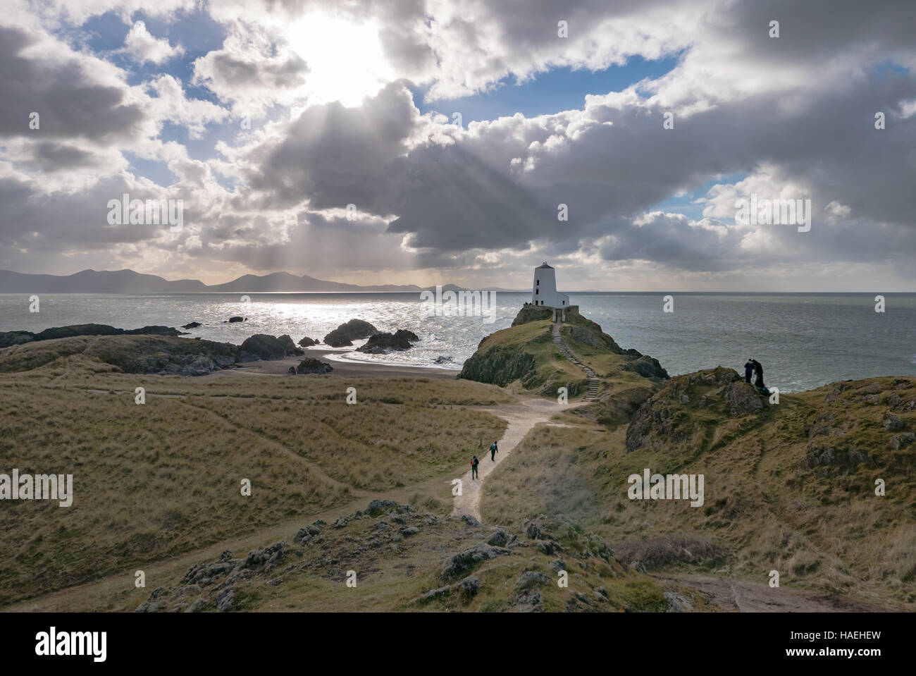 Llanddwyn lighthouse against a sunlit sea Stock Photo