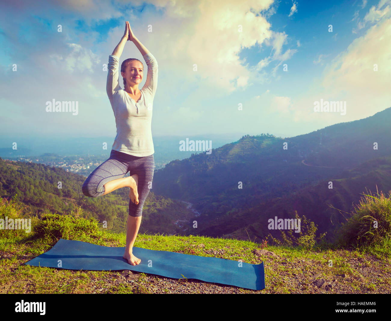 Woman in yoga asana Vrikshasana tree pose in mountains outdoors Stock ...
