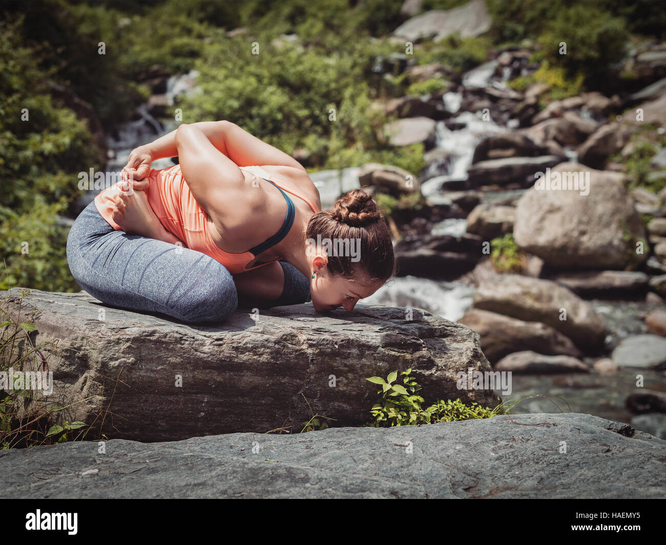 Young sporty fit woman doing yoga oudoors at tropical waterfall Stock ...