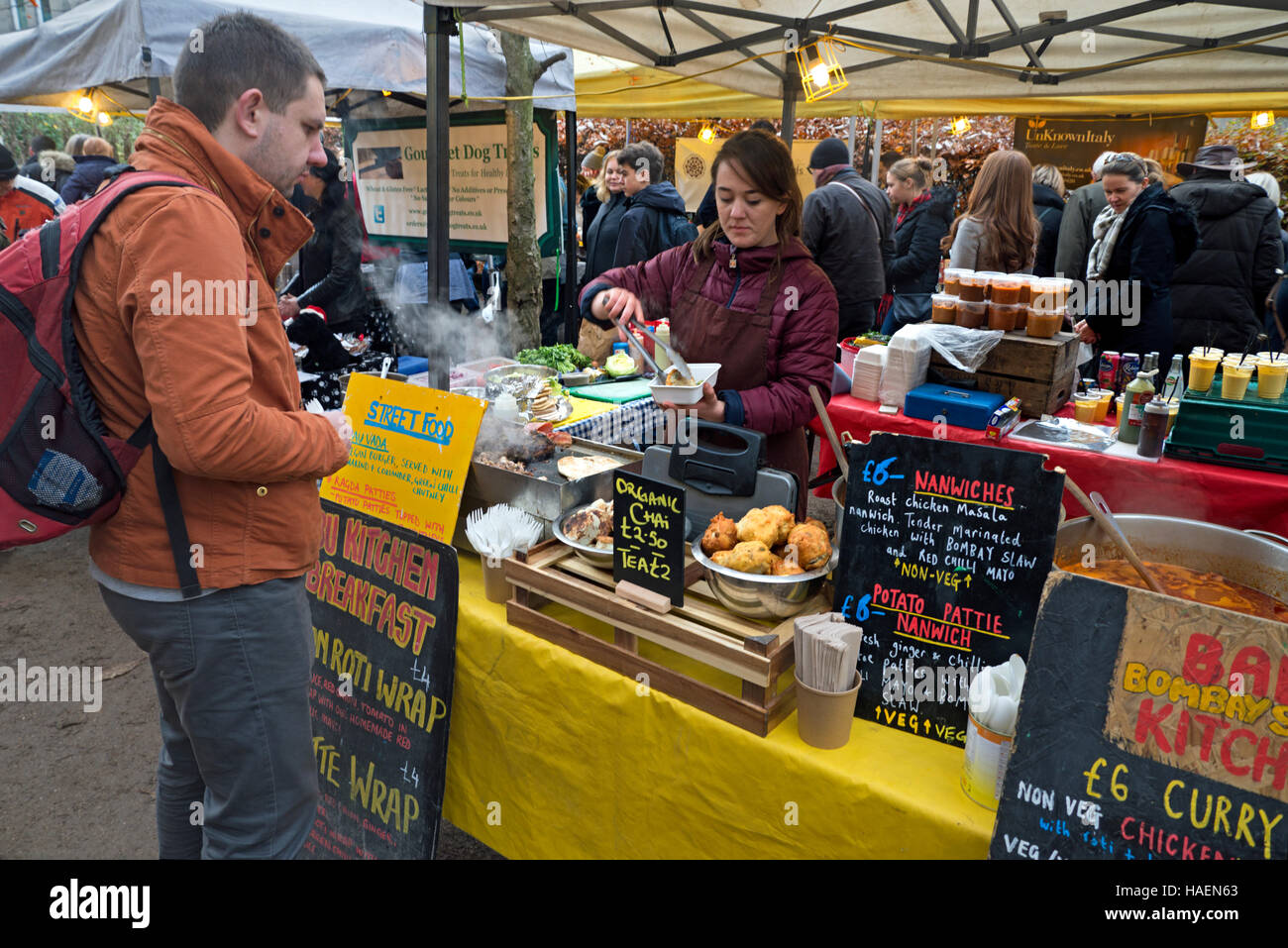 A customer being served at a streetfood stall at Stockbridge Sunday Market in Edinburgh, Scotland, UK. Stock Photo