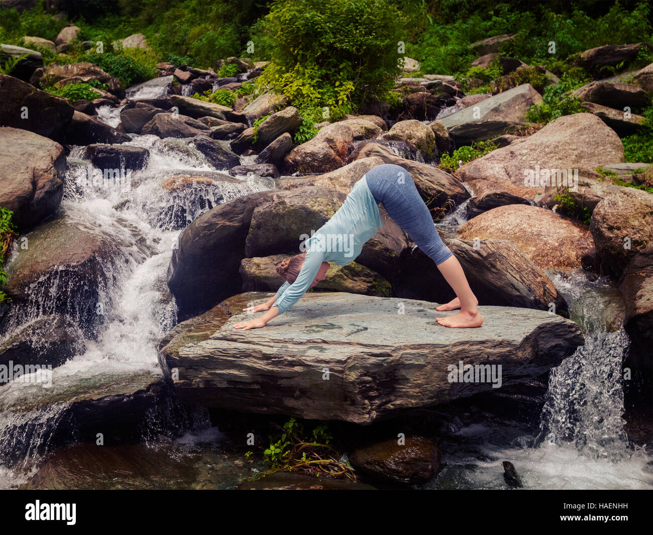 Young sporty fit woman doing yoga oudoors at tropical waterfall Stock ...