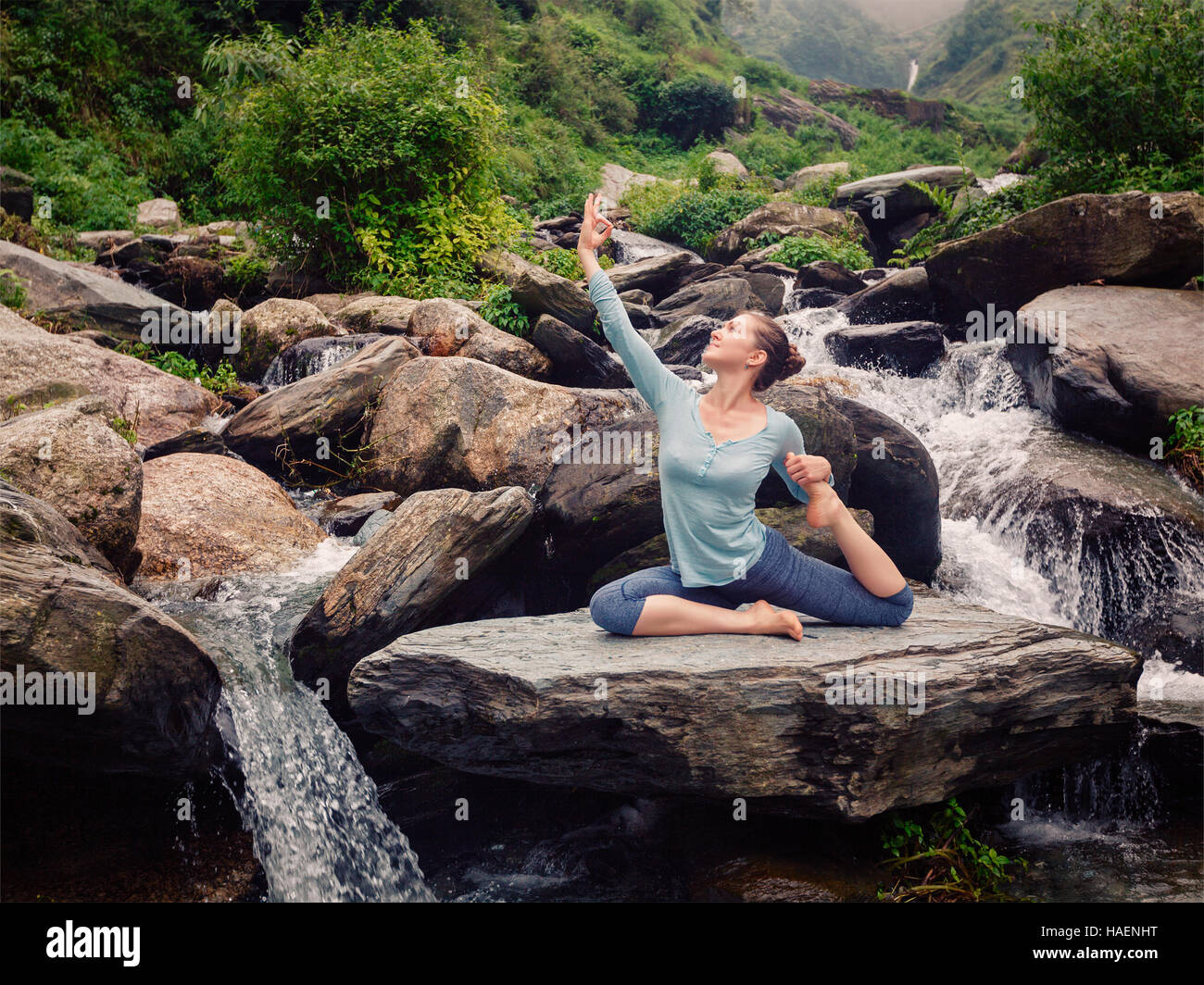 Sorty fit woman doing yoga asana outdoors at tropical waterfall Stock ...