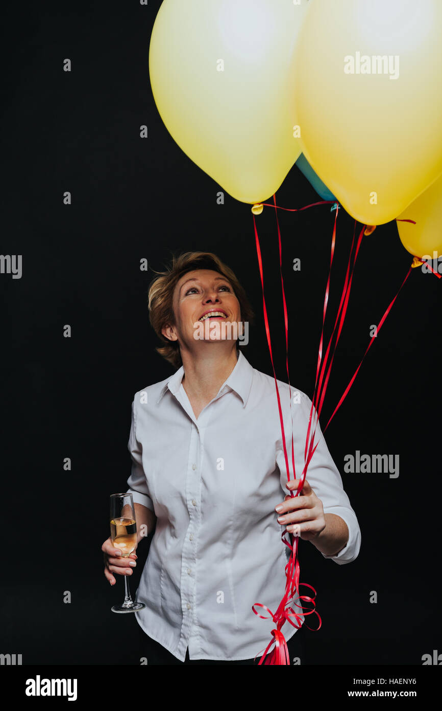 Happy woman with balloons and wineglass Stock Photo