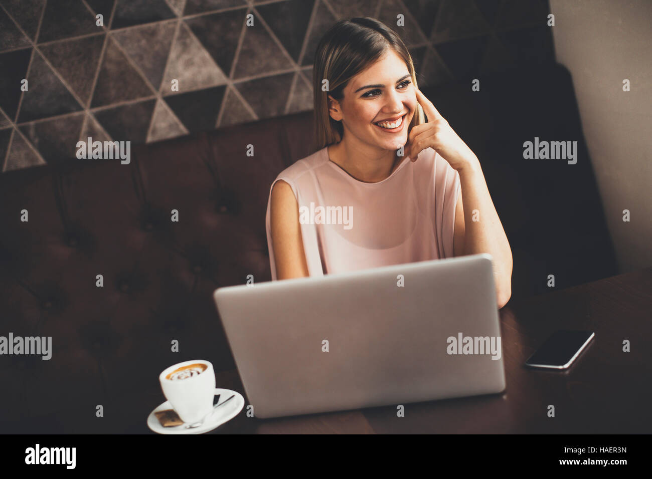 Young woman with laptop sitting in cafe Stock Photo - Alamy