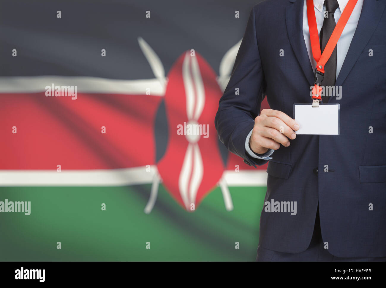 Businessman holding name card badge on a lanyard with a flag on background - Kenya Stock Photo