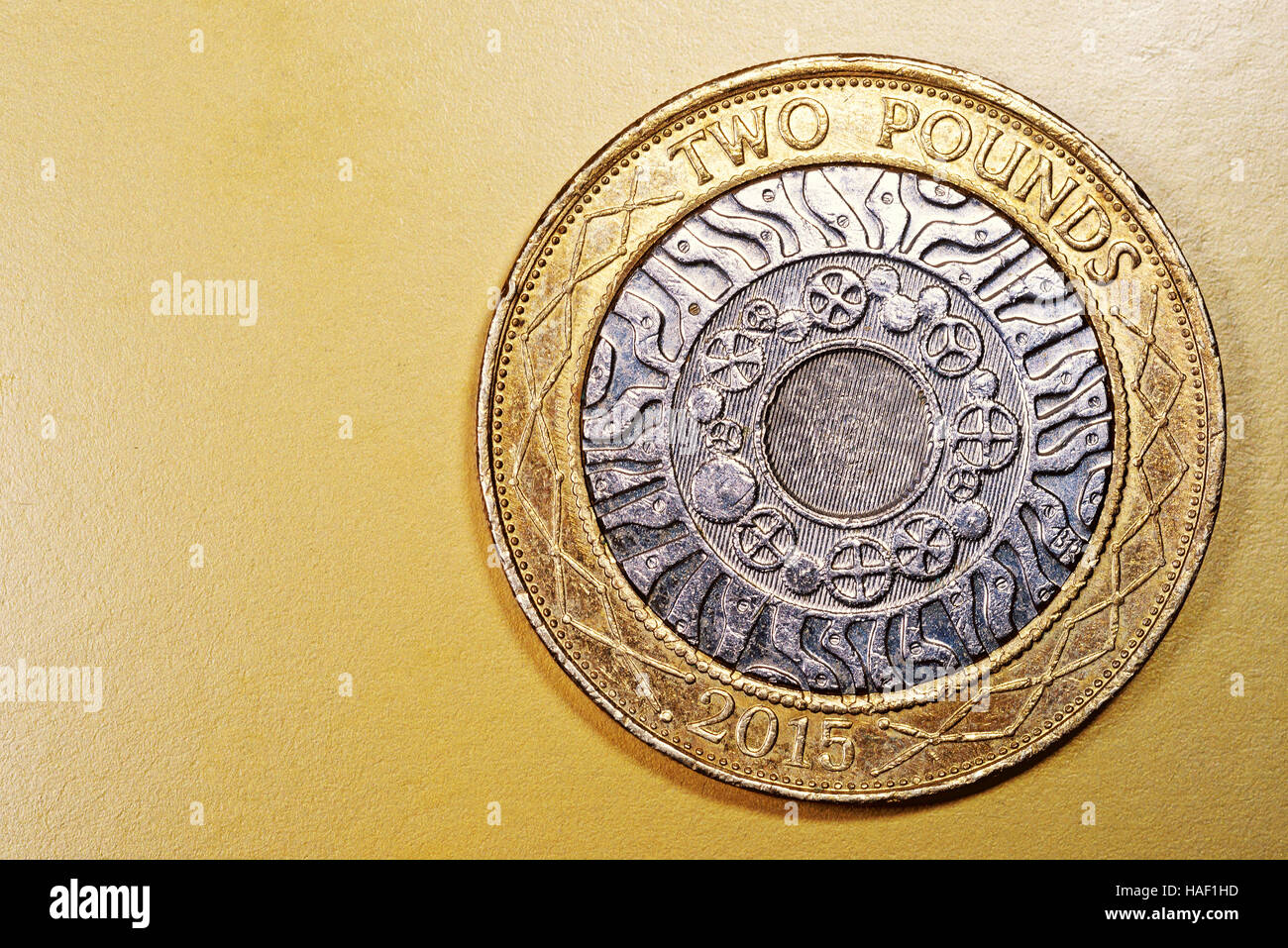 Two pound English currency coin in a macro close-up on a rich luxurious golden background. Copyspace area for finance, banking, and economics designs Stock Photo