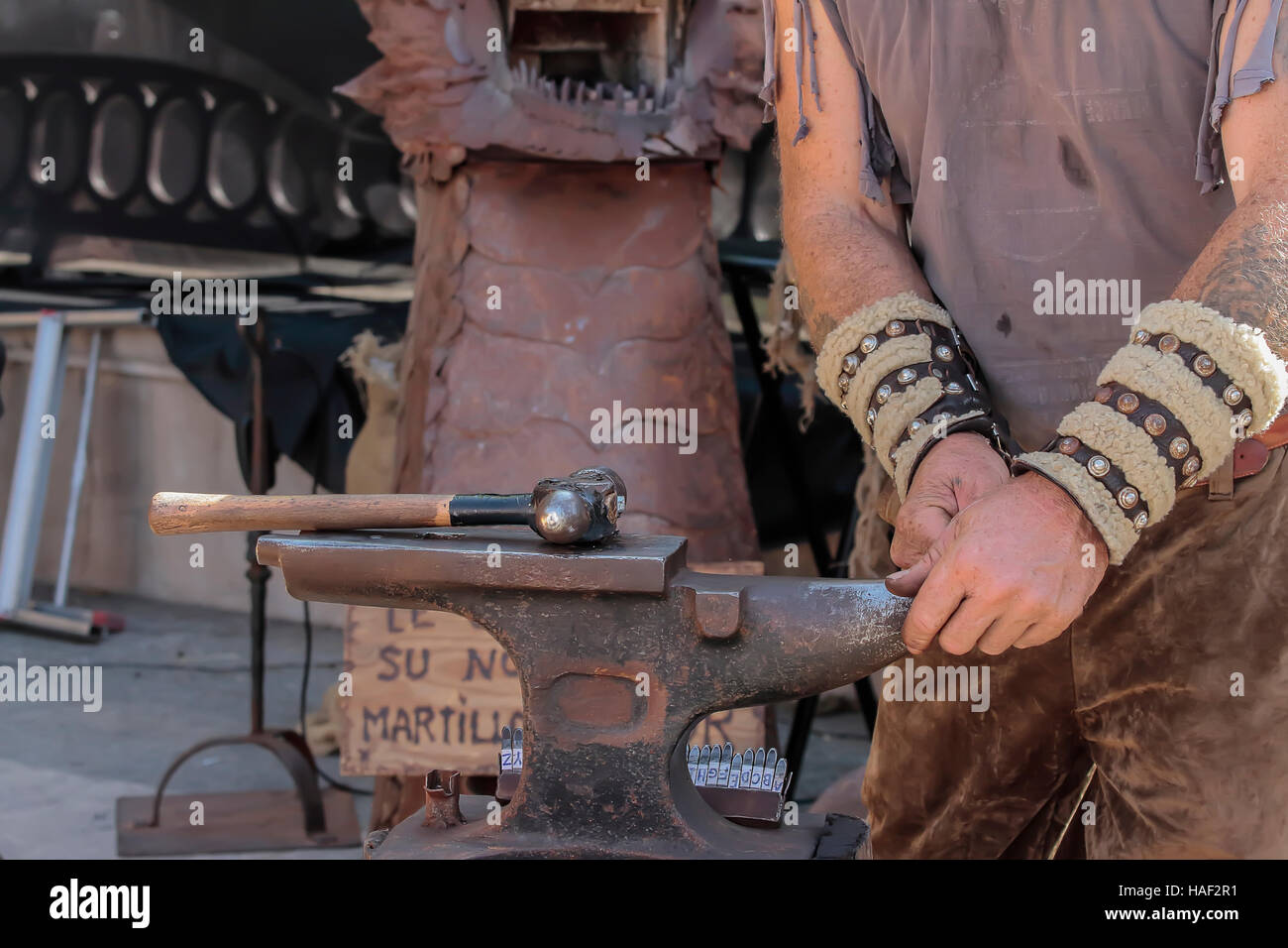 foreground of hands of a blacksmith working on the anvil Stock Photo