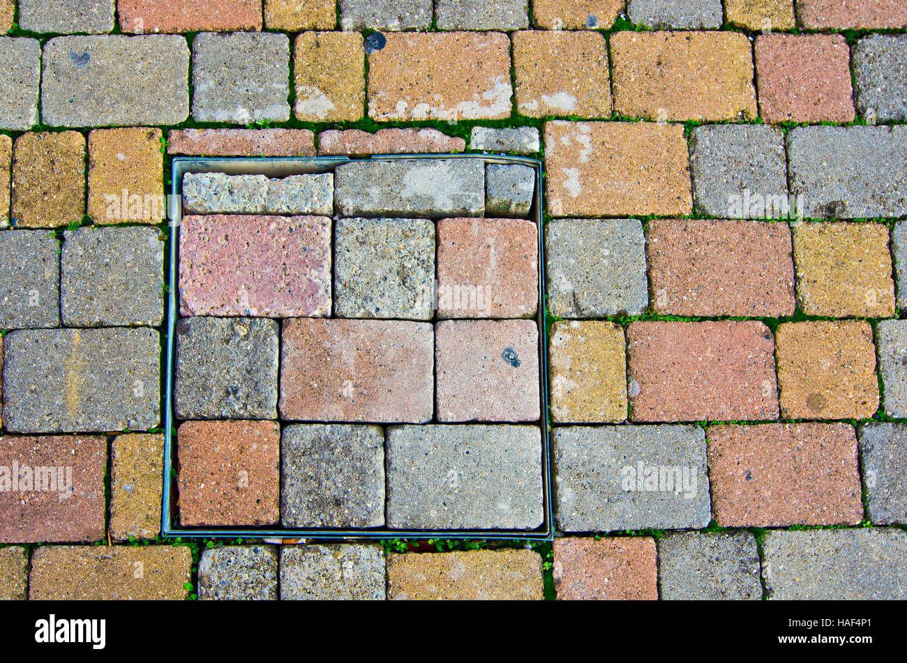 paving pattern stone blocks with shape and color irregular with manhole Stock Photo