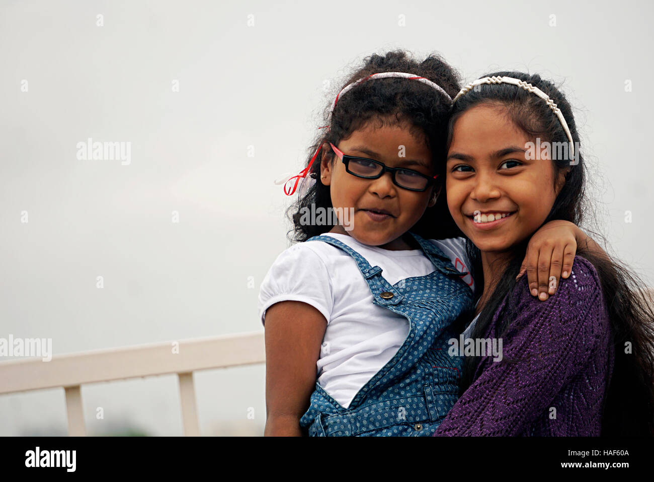 Two young girl hugging and laughing, Pune, Maharashtra. Stock Photo