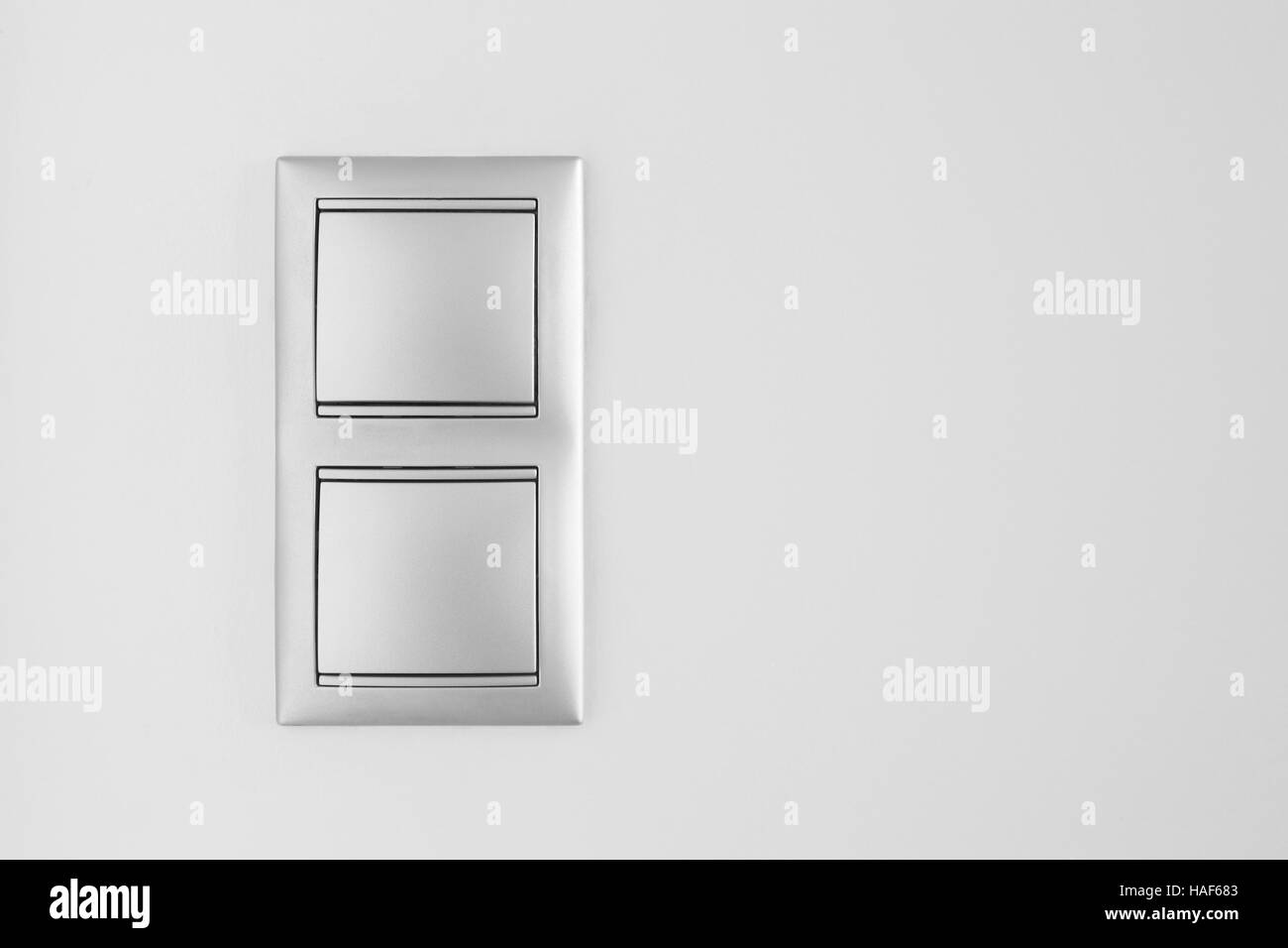 Double metallic light switch over a white wall. Copy space. Horizontal Stock Photo