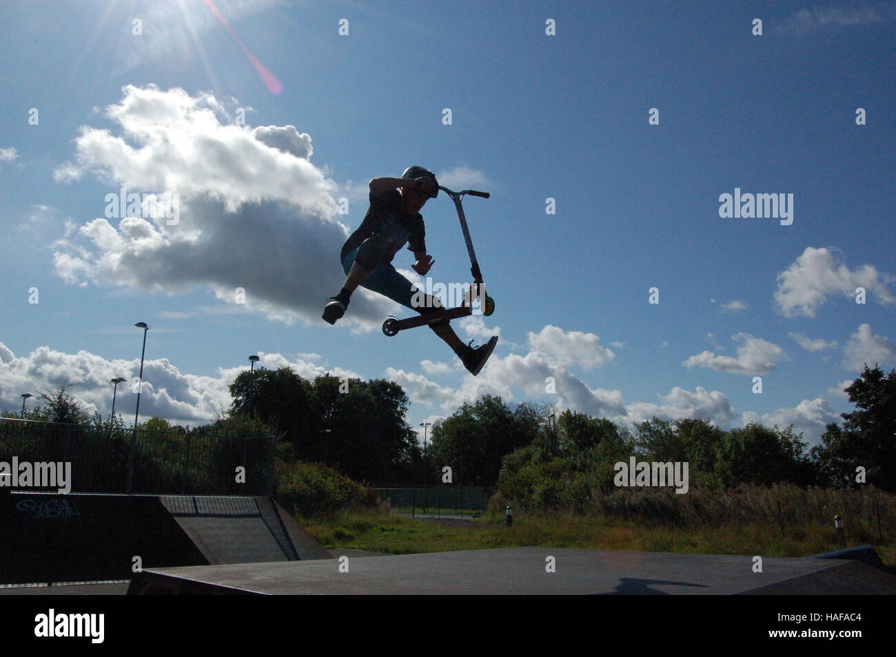 scooter trick on a ramp with sun Stock Photo Alamy