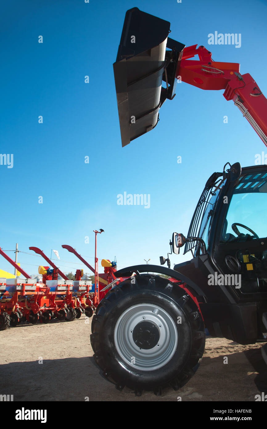 Excavator with bucket and sowing machinery on the background. Stock Photo