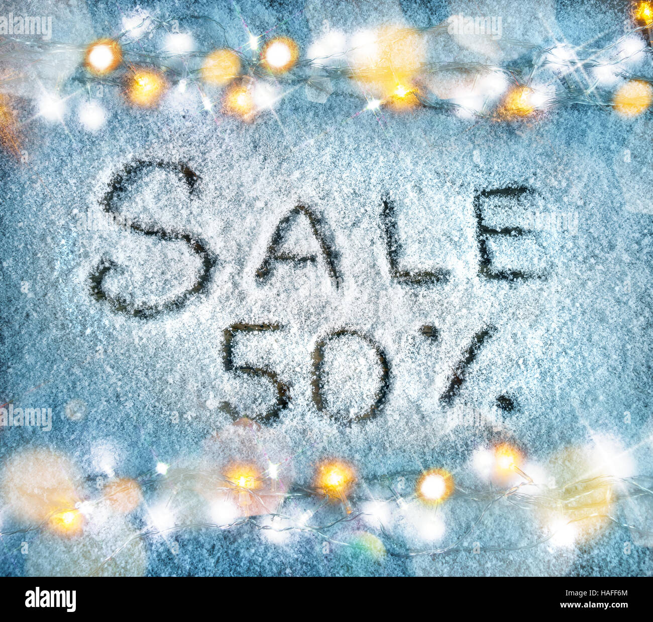 Sale 50 percent off on snow background. Merry Christmas and Happy New Year discount!! Top view. Stock Photo
