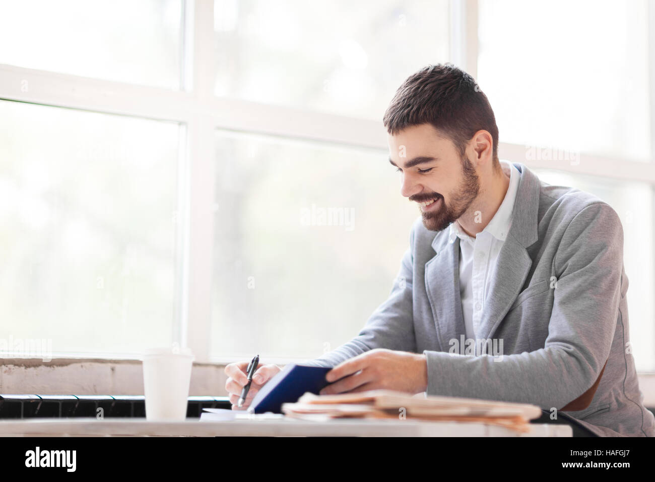 Happy professional making notes or writing working plan Stock Photo - Alamy