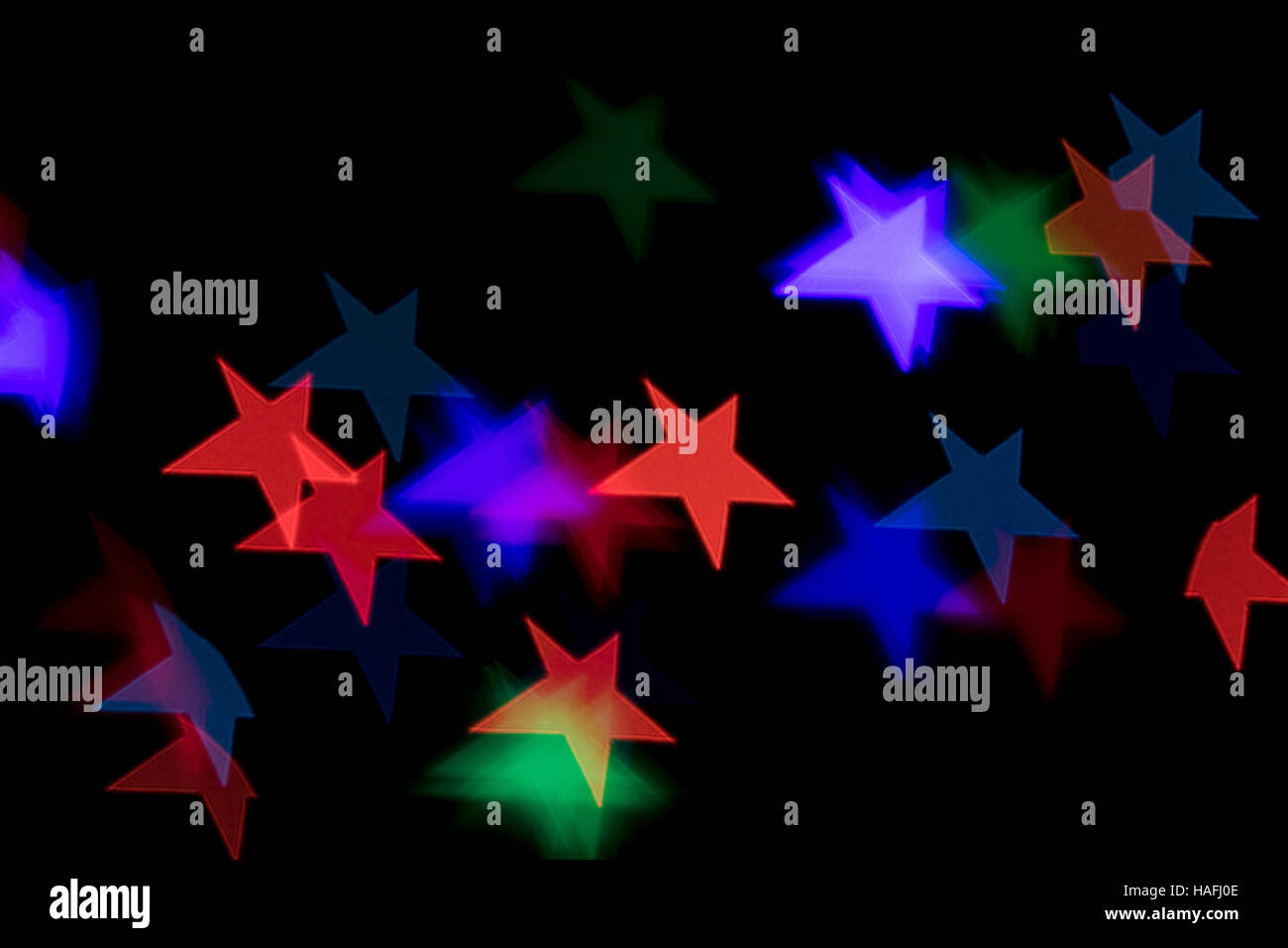 Bokeh vague colorful star shaped scattered celebration lights on black background Stock Photo