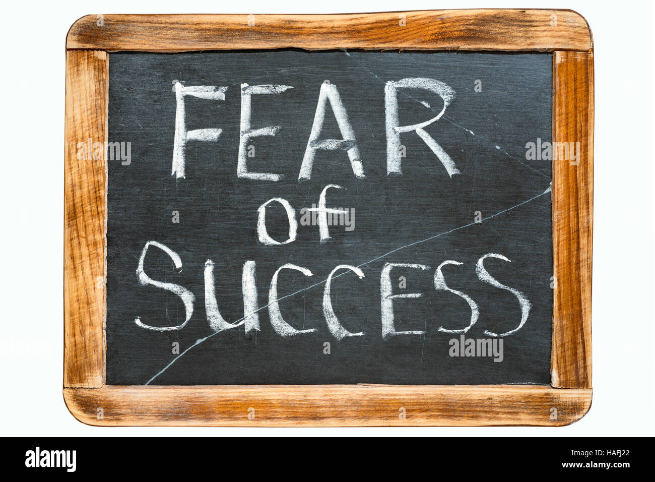 fear of success phrase handwritten on vintage school slate board isolated on white Stock Photo