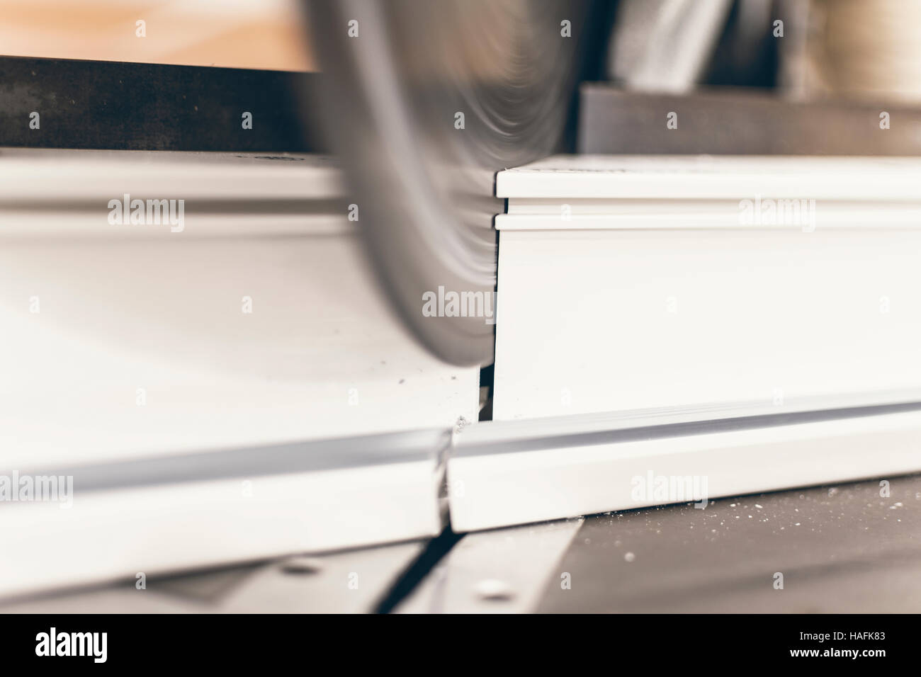 Circular Saw Cutting PVC Profile Close Up. Plastic Window and Door