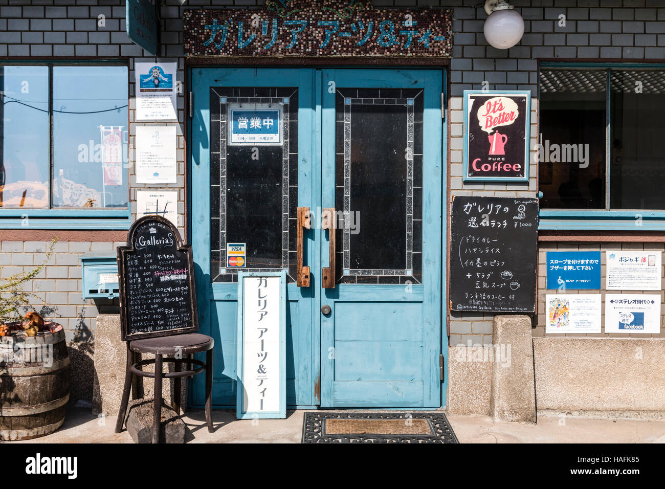 Japan, Tatsuno. Light blue double door to family-run coffee shop café, vintage 'pure coffee' poster, menu board on chair. Exterior. Stock Photo