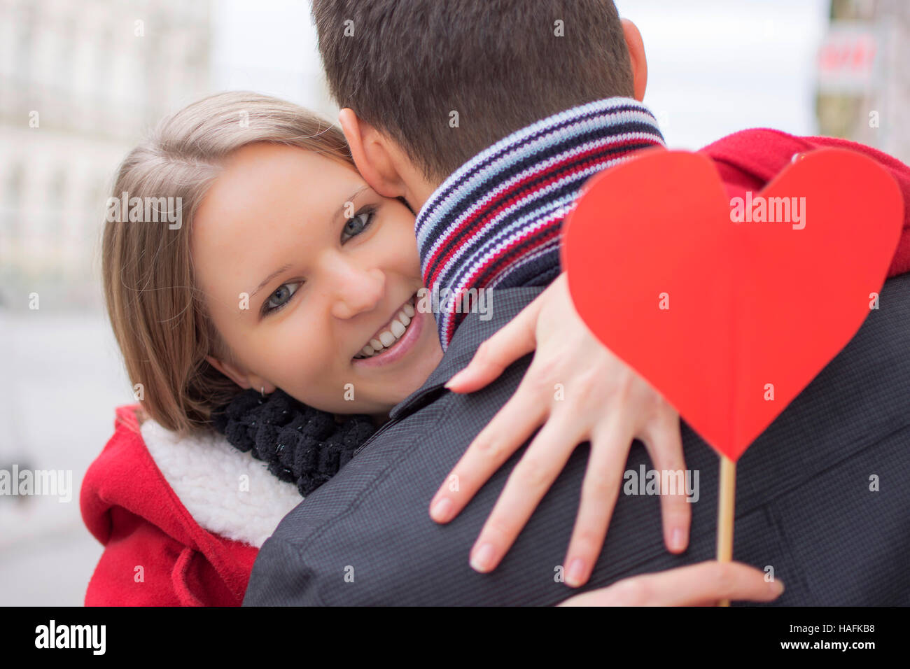 Man with his lovely sweetheart girl kiss at Lover's valentine day.  Valentine Couple. Couple kiss and hug. On background red balloons hearts.  Love concept. Happy smile girl. Lovers touch foreheads Photos