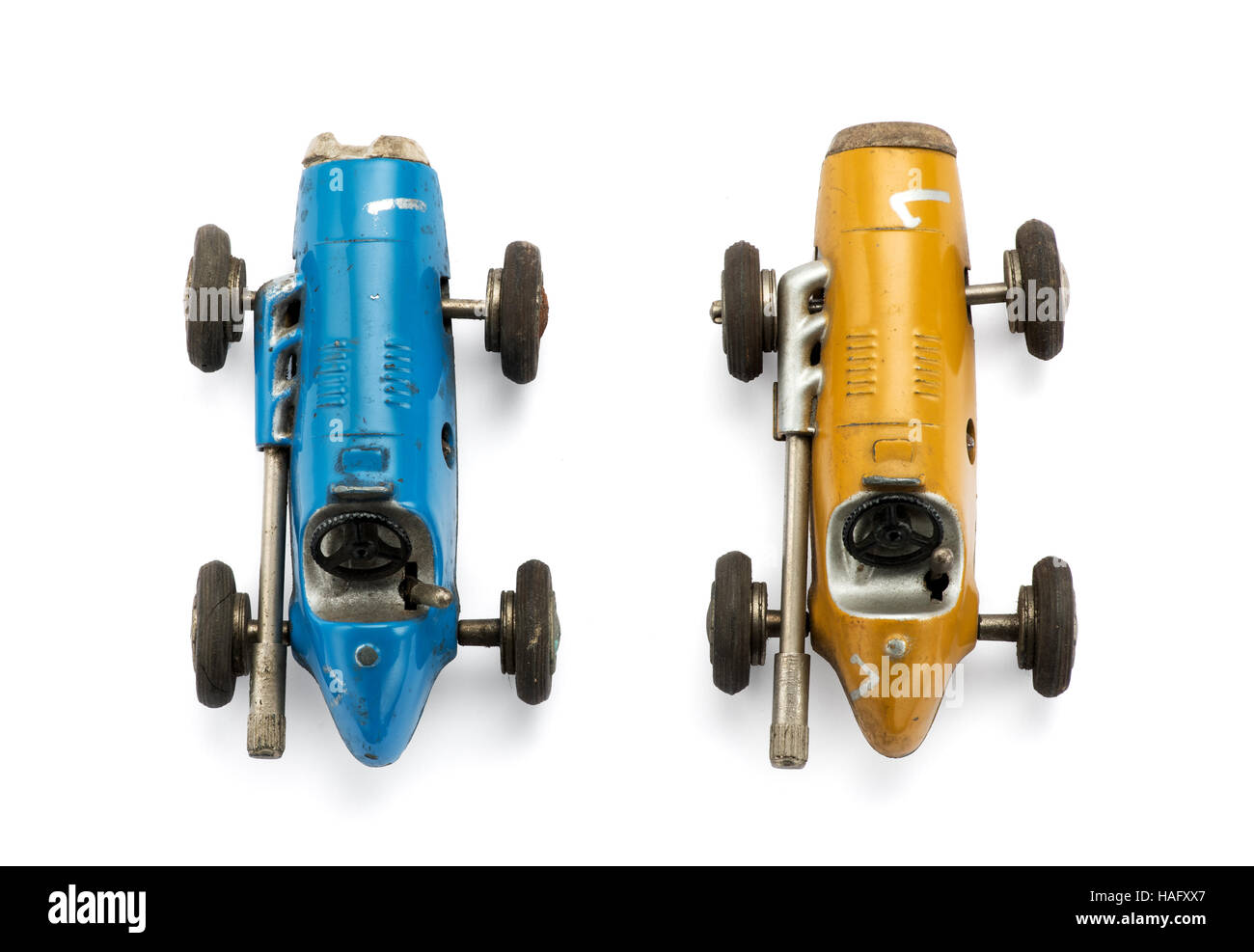 View from the top of two model vintage toy racing cars side by side in yellow and blue isolated on white Stock Photo