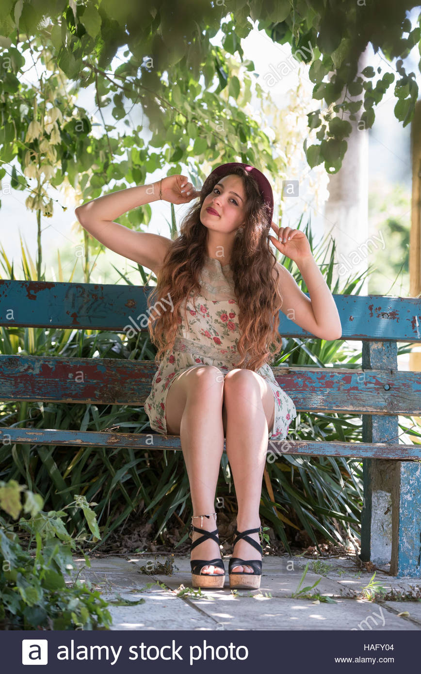 Girl With Curly Hair Wear Short Floral Dress And Red Bowler