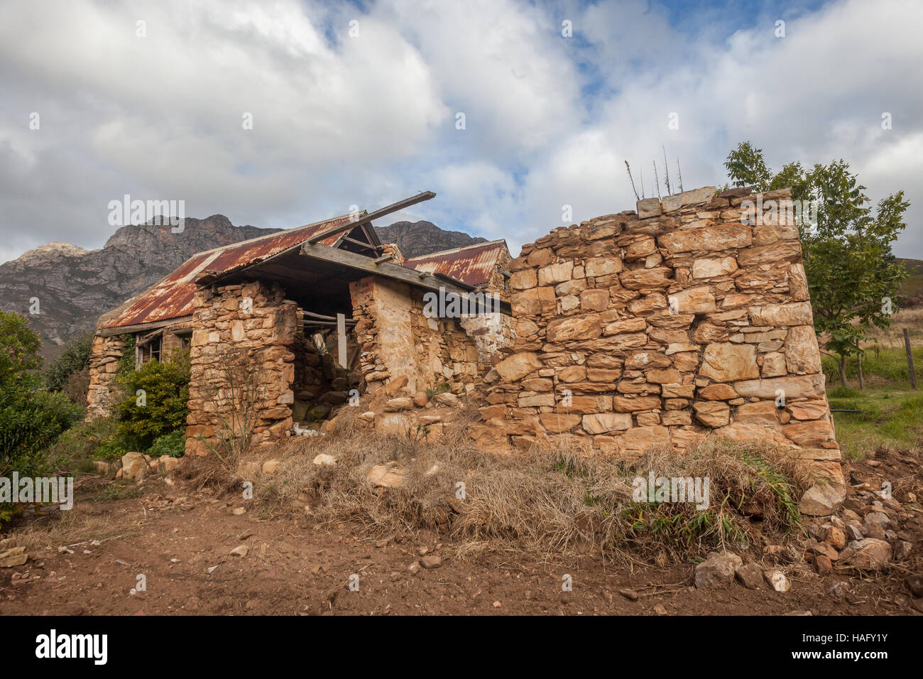 Old settler stone house broken abandoned in mountain terrain Stock