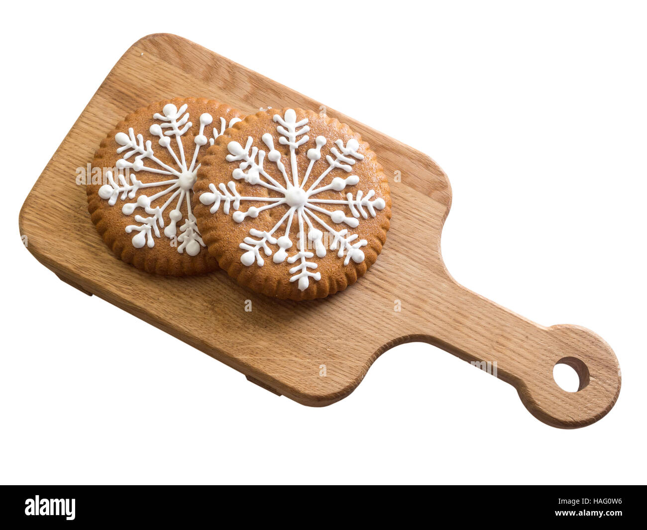 Gingerbread with snowflakes of the glaze. Sweets for Christmas. Two sticks on a wooden board. Stock Photo
