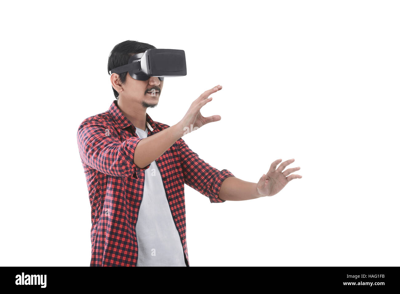 Young asian man experiencing virtual reality through a VR headset isolated on white background Stock Photo