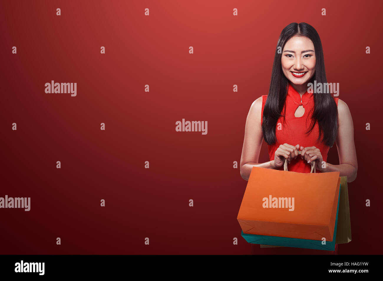 Chinese woman in cheongsam dress holding shopping bag. Chinese new year ...