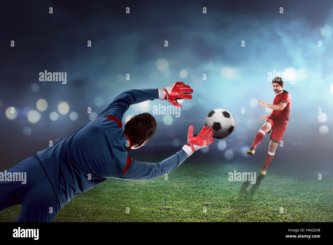 Football player kick ball and goalkeeper try to catch Stock Photo Alamy