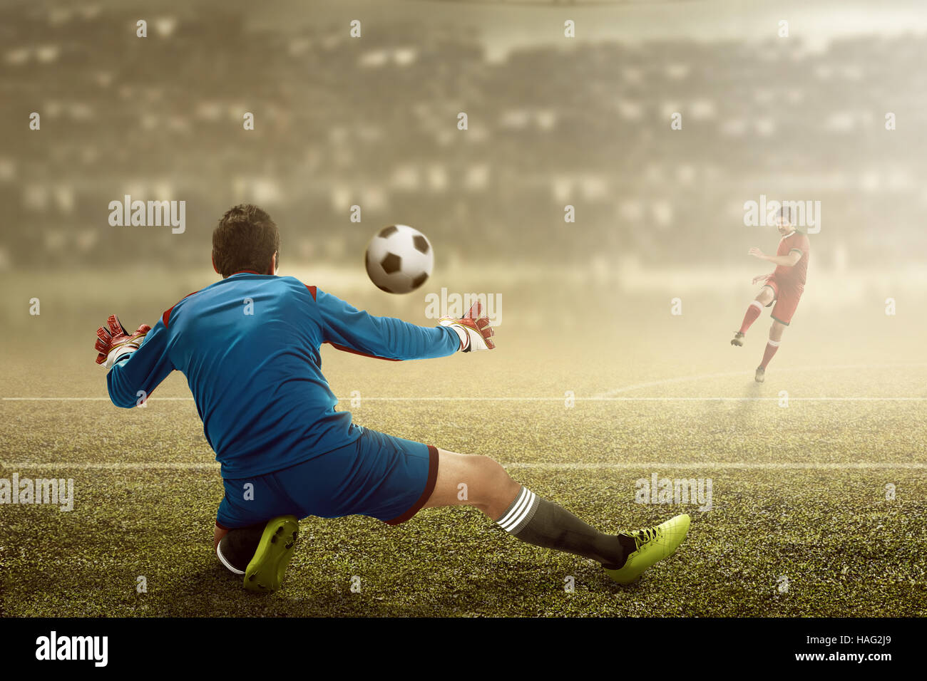 Football player kick ball and goalkeeper try to catch Stock Photo Alamy