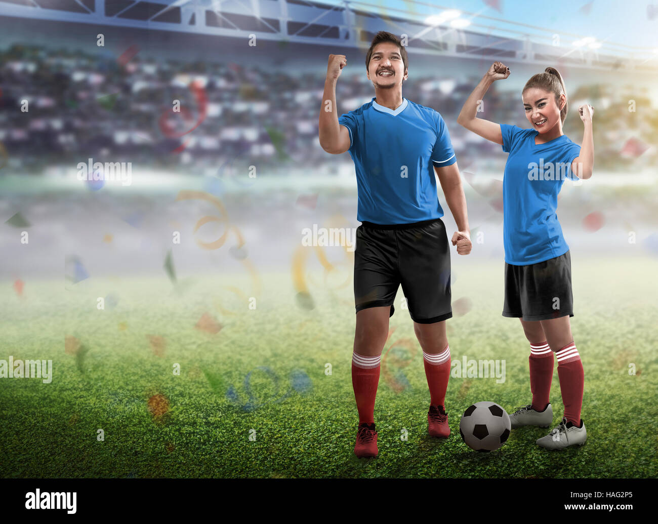 Young couple wearing football jersey standing on the field Stock Photo -  Alamy