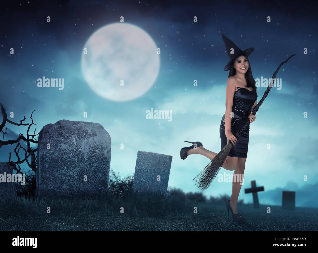Pretty asian witch woman want to fly with magic broom in the night Stock Photo
