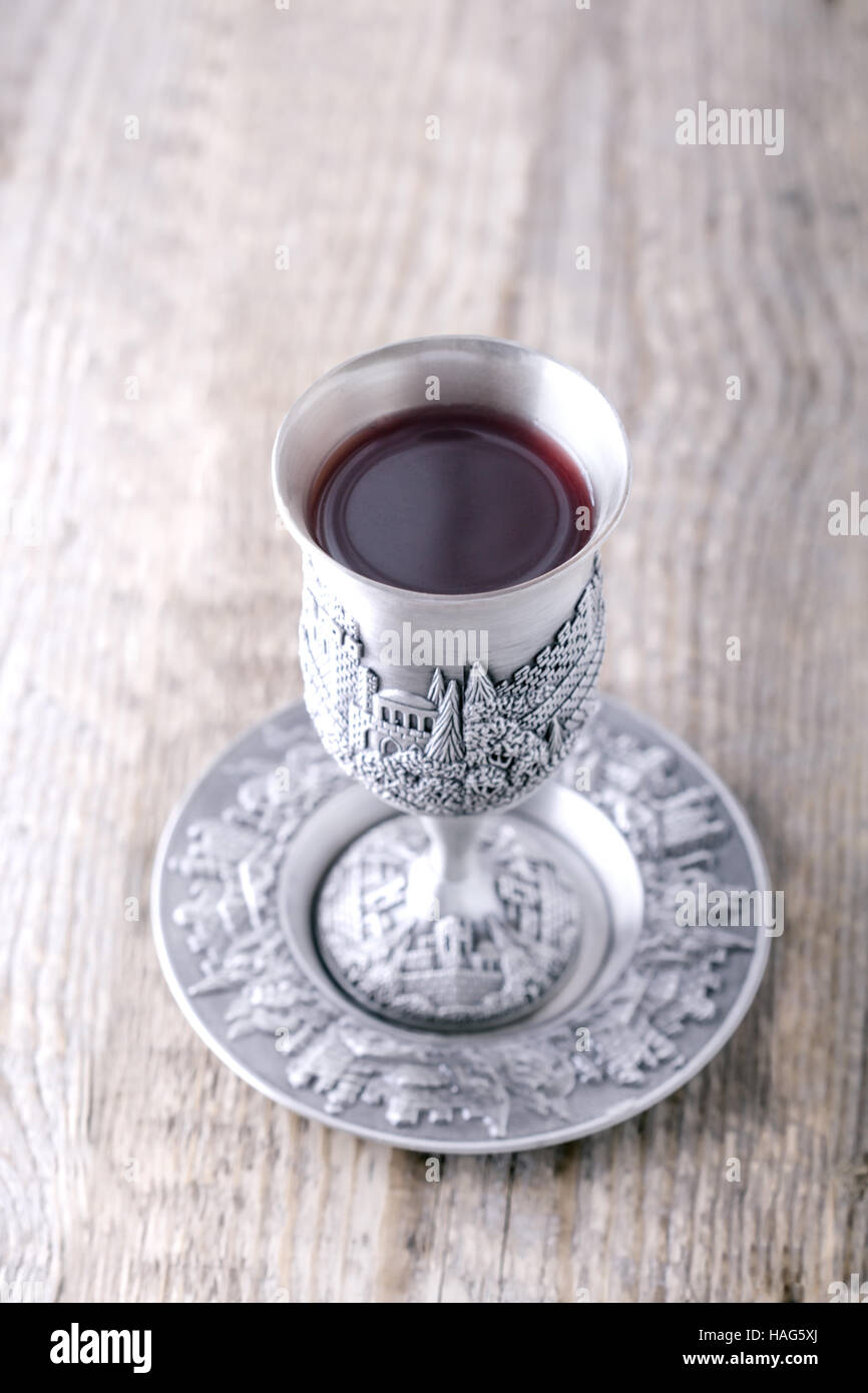 Silver kiddush cup with wine on the wooden table Stock Photo