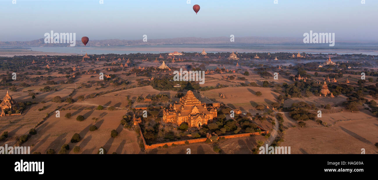 Hot air balloons flying over the temples of the Archaeological Zone in Bagan in the early morning sunlight. Myanmar. Stock Photo