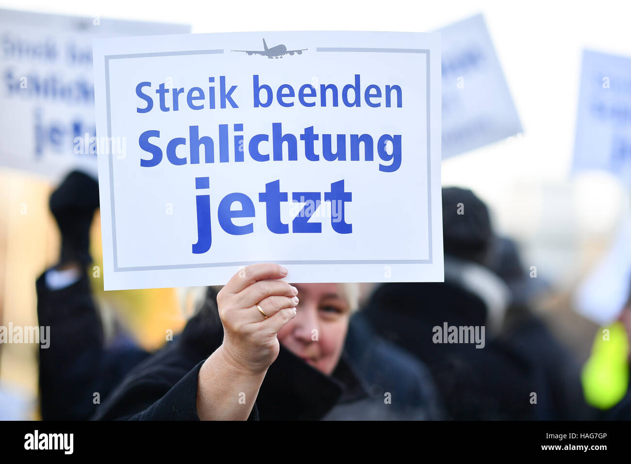 A counter demontrator holding a sign that reads 'Streik beenden. Schlichtung jetzt' (lit. End the strike. Arbitration now) during a demonstration by the Betriebsrat des Frankfurter Bodenpersonals (lit. works committee of the Frankfurt ground crew) in Frankfurt am Main, Germany, 30 November 2016. In the Lufthansa industrial dispute there is a public showdown between the striking pilots and sections of the other staff. Photo: Uwe Anspach/dpa © dpa picture alliance/Alamy Live News Stock Photo