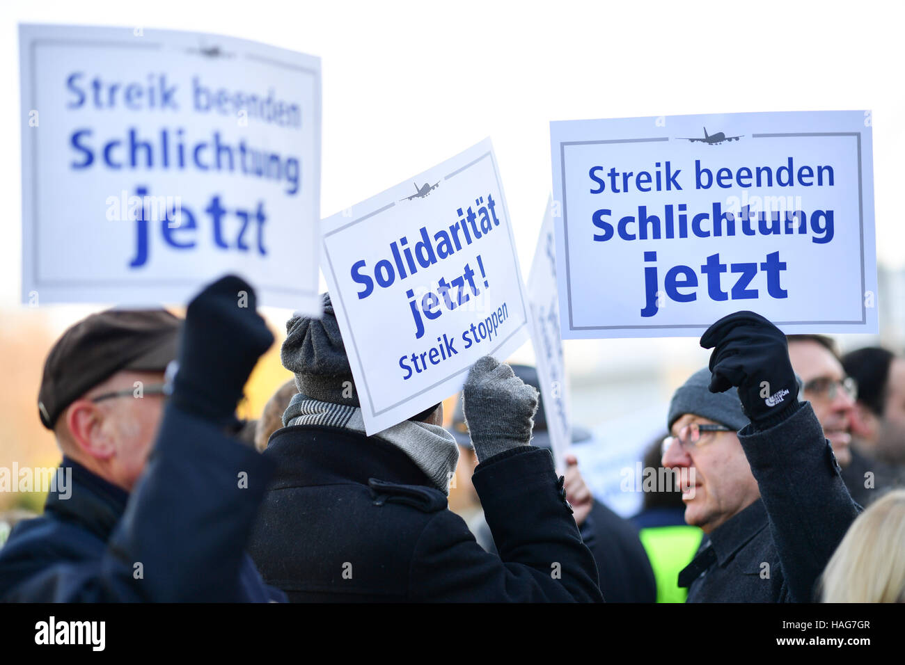 Counter demontrators holding signs that read 'Solidaritaet jetzt!' (lit. solidarity now) and 'Streik beenden. Schlichtung jetzt' (lit. End the strike. Arbitration now) during a demonstration by the Betriebsrat des Frankfurter Bodenpersonals (lit. works committee of the Frankfurt ground crew) in Frankfurt am Main, Germany, 30 November 2016. In the Lufthansa industrial dispute there is a public showdown between the striking pilots and sections of the other staff. Photo: Uwe Anspach/dpa © dpa picture alliance/Alamy Live News Stock Photo