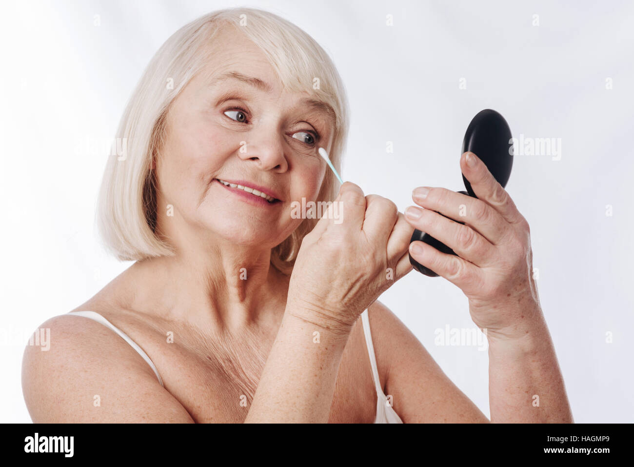Positive senior woman looking into the mirror Stock Photo