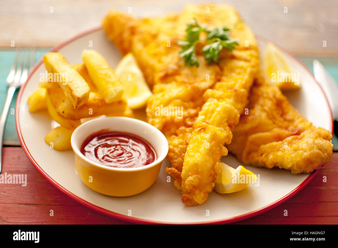 Two pieces of battered fish on a plate with chips Stock Photo Alamy