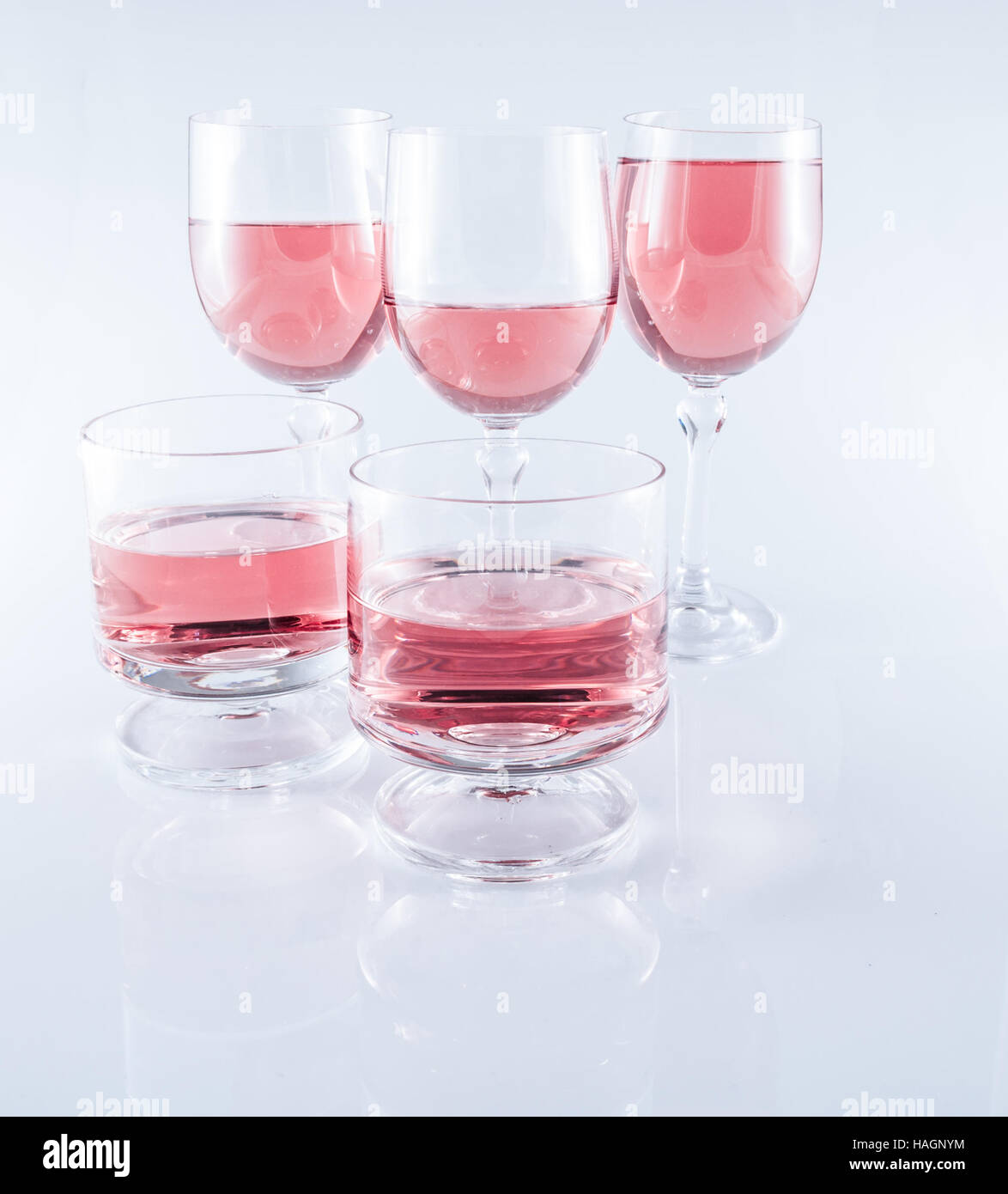 Rosè wine in stemmed glasses on white background with reflection Stock Photo