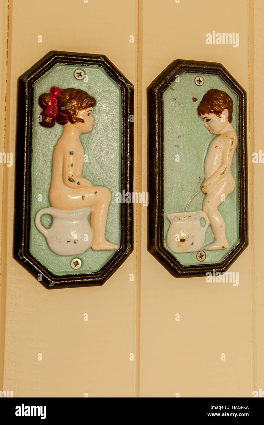A boy and girl bathroom sign on a wooden door. Stock Photo