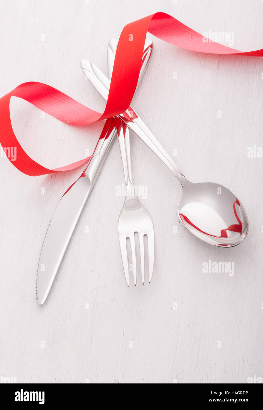 Knife, fork and spoon with red ribbon Stock Photo Alamy