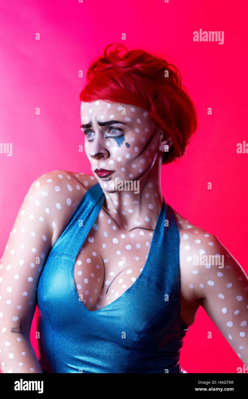 Portrait in pop art comic strip style featuring determined red haired woman with white dots, blue tears and contouring on skin Stock Photo