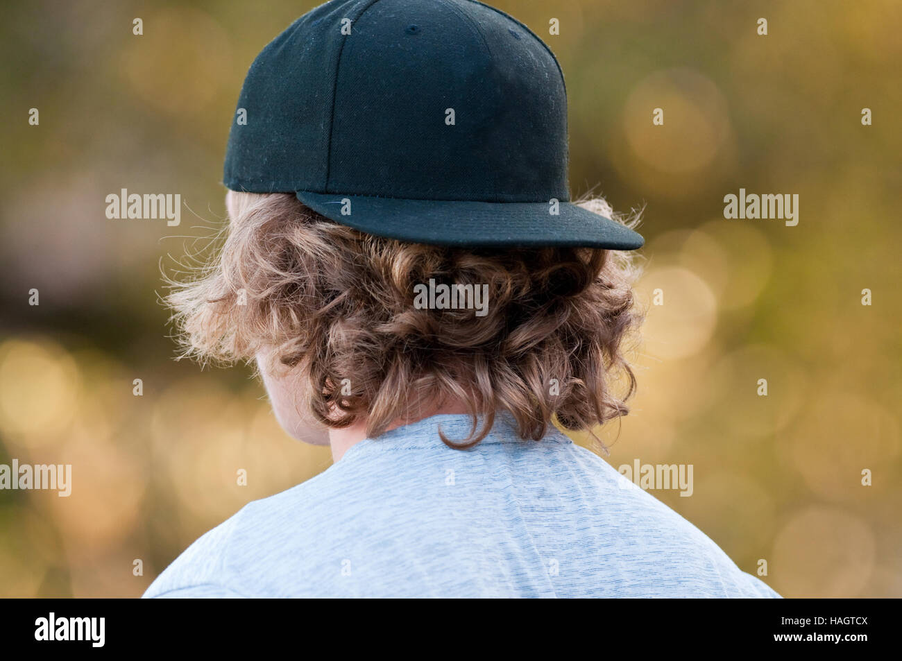 Teenage boy with long hair looking away in a black baseball hat Stock Photo - Alamy Teenage boy with long hair looking away in a black baseball hat Stock Photo - Alamy