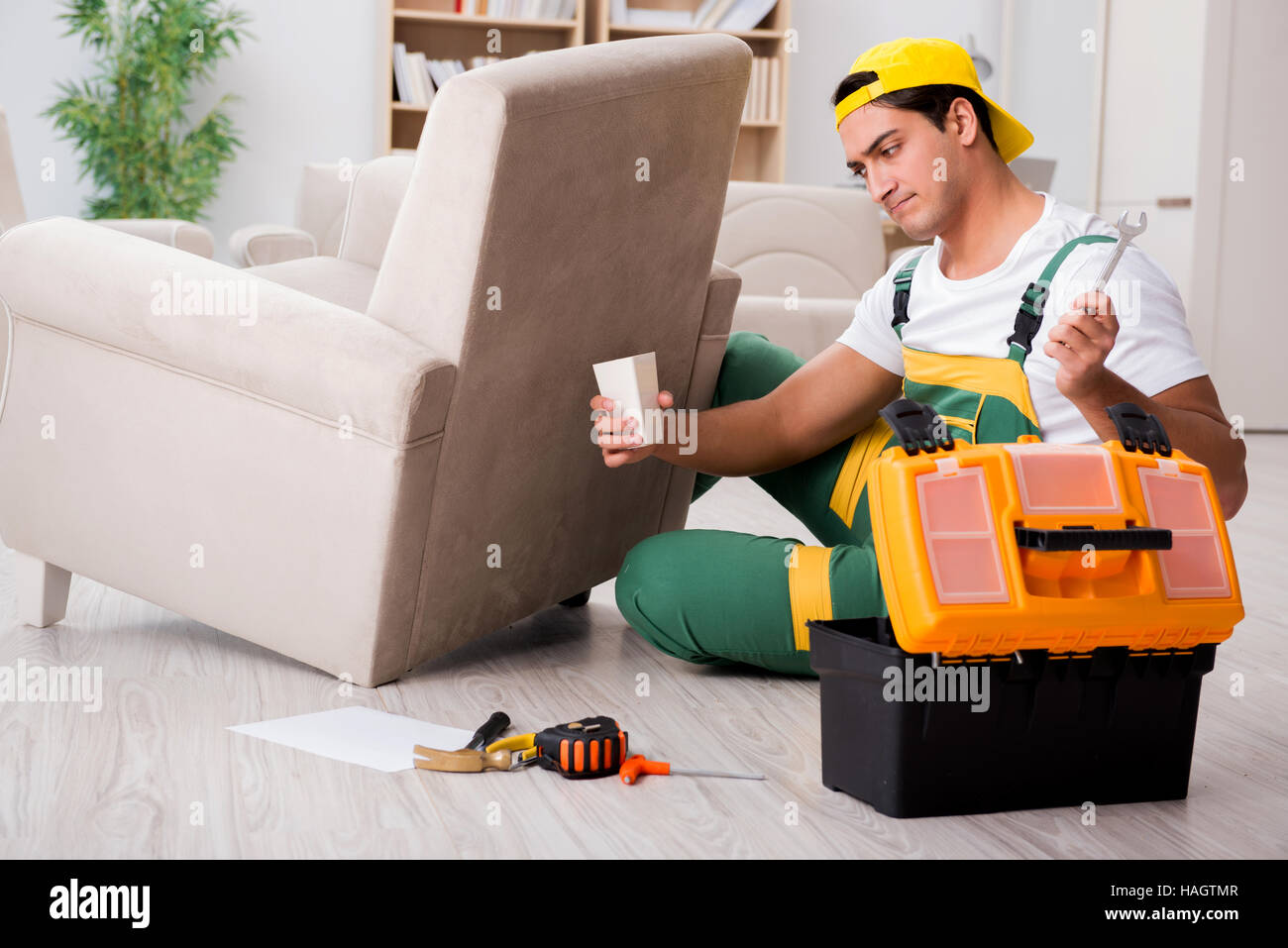 Furniture repairman repairing armchair at home Stock Photo Alamy