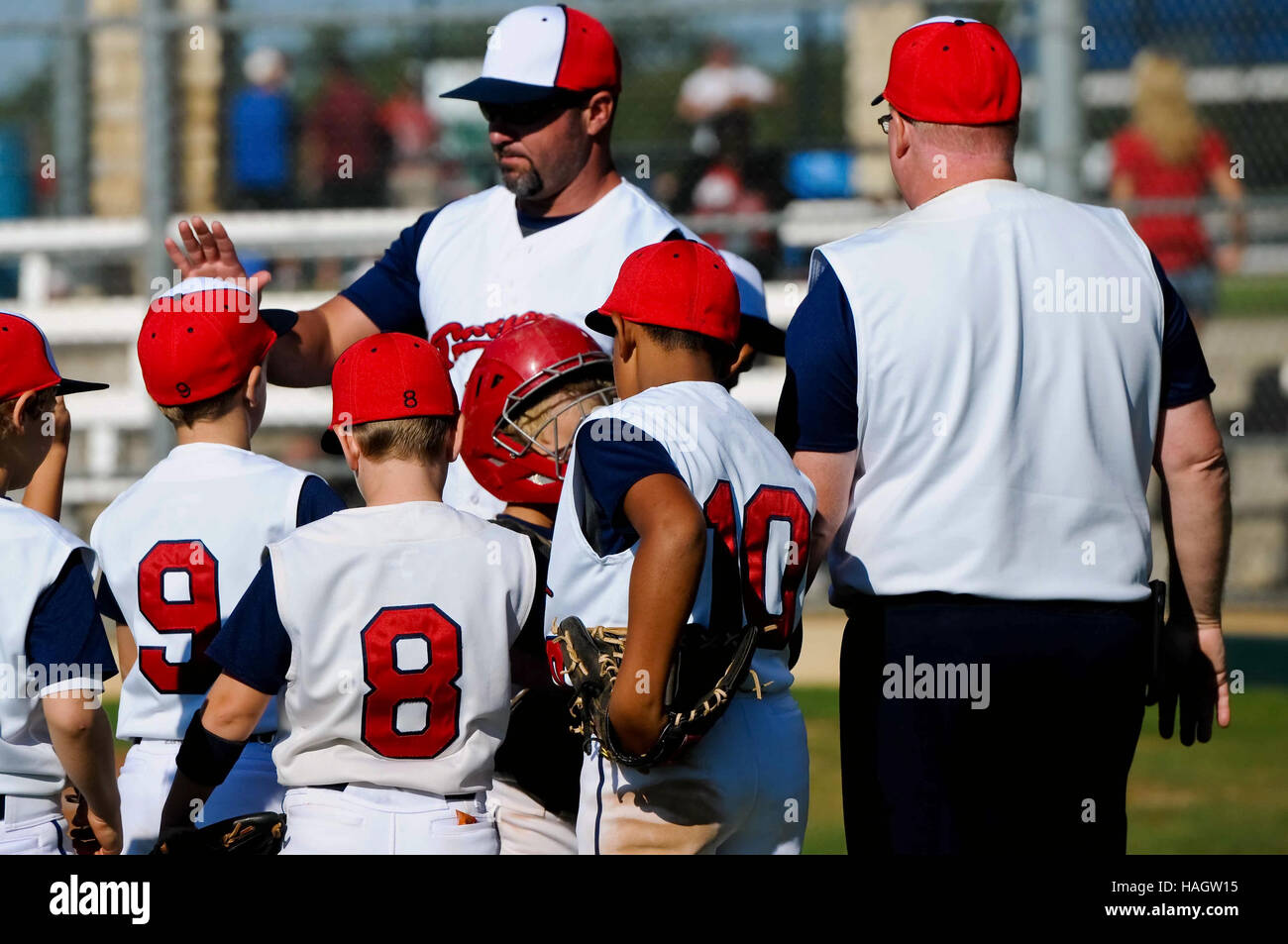 Baseball team huddled with their coach getting praise. Stock Photo